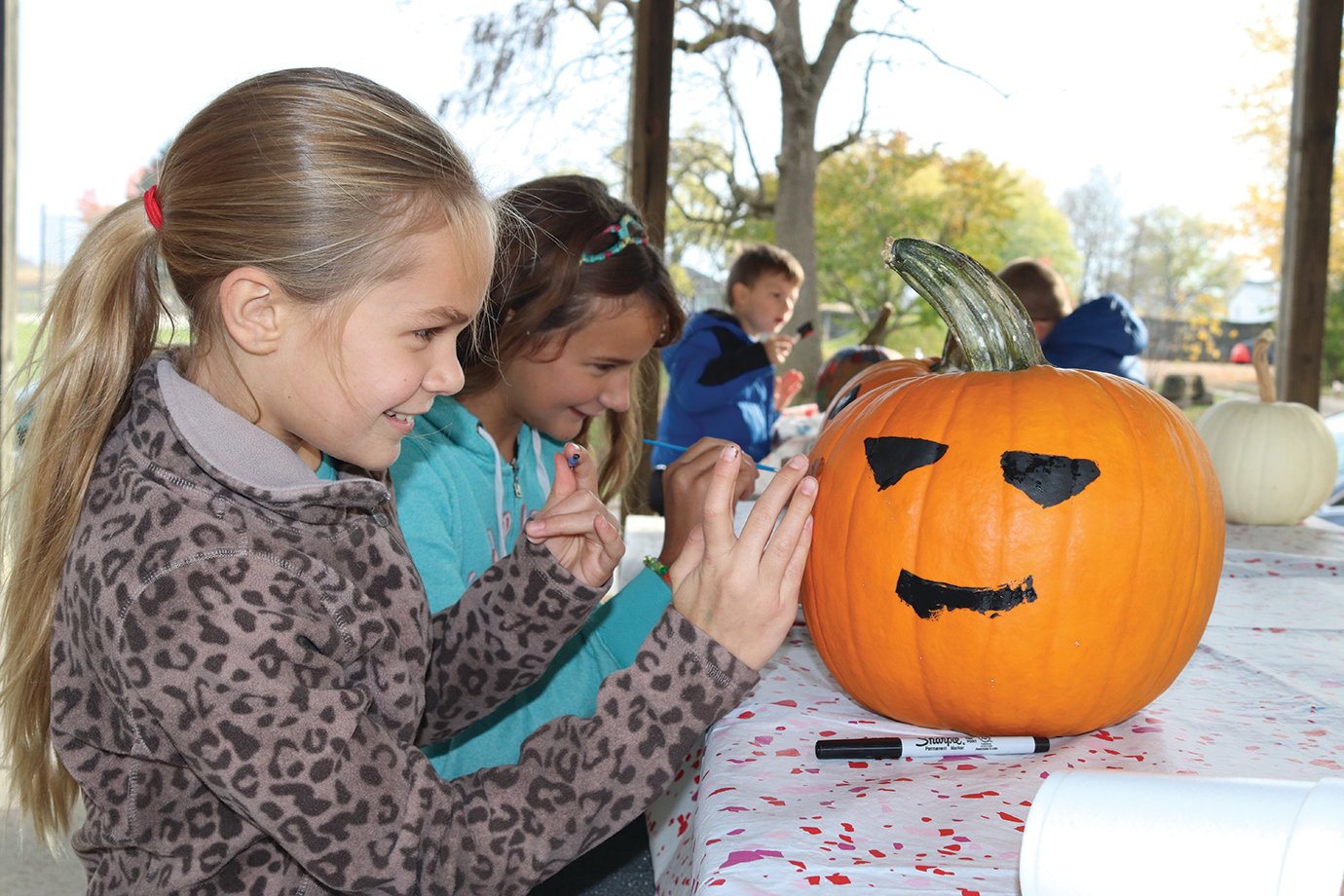 Sophia Johnson, 11, and sister Ella Johnson, 12, paint some Halloween pumpkins Thursday at Bulldog Park in Linden as part of the Linden Library's efforts to provide children with fun activities outdoors during the coronavirus (COVID-19) pandemic.